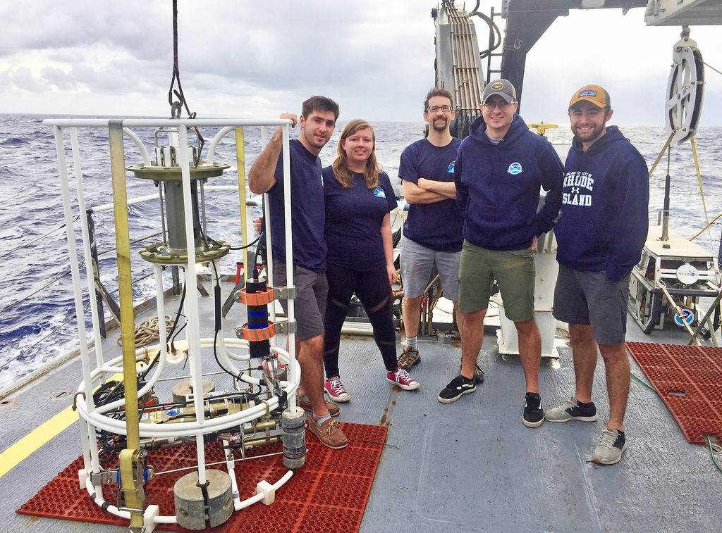 From left: Grady Bolan, Allison Redington, Associate Professor Stephen Licht, Sean Nagle and Josh Allder standing next to a CTD device on the deck of the Okeanos Explorer. Photo via Josh Allder/URI.
