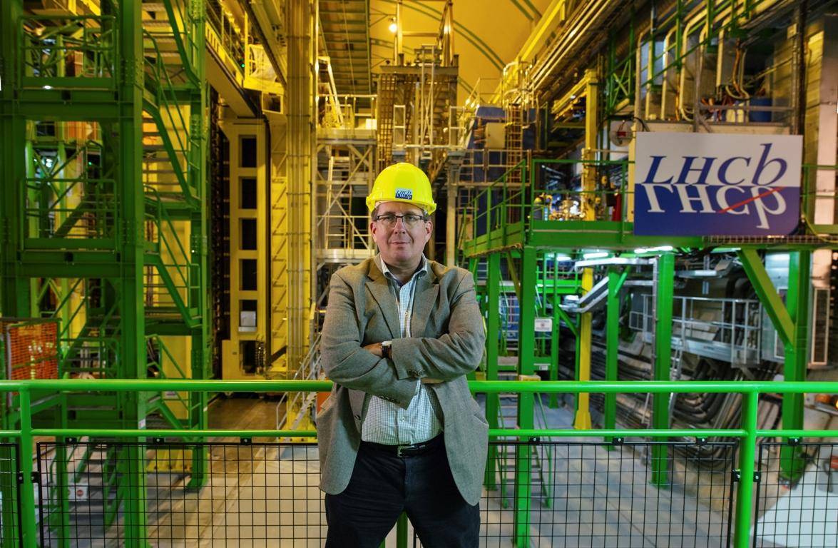 CERN scientist Guy Wilkinson stands in front of the LHCb detector. Image - CERN