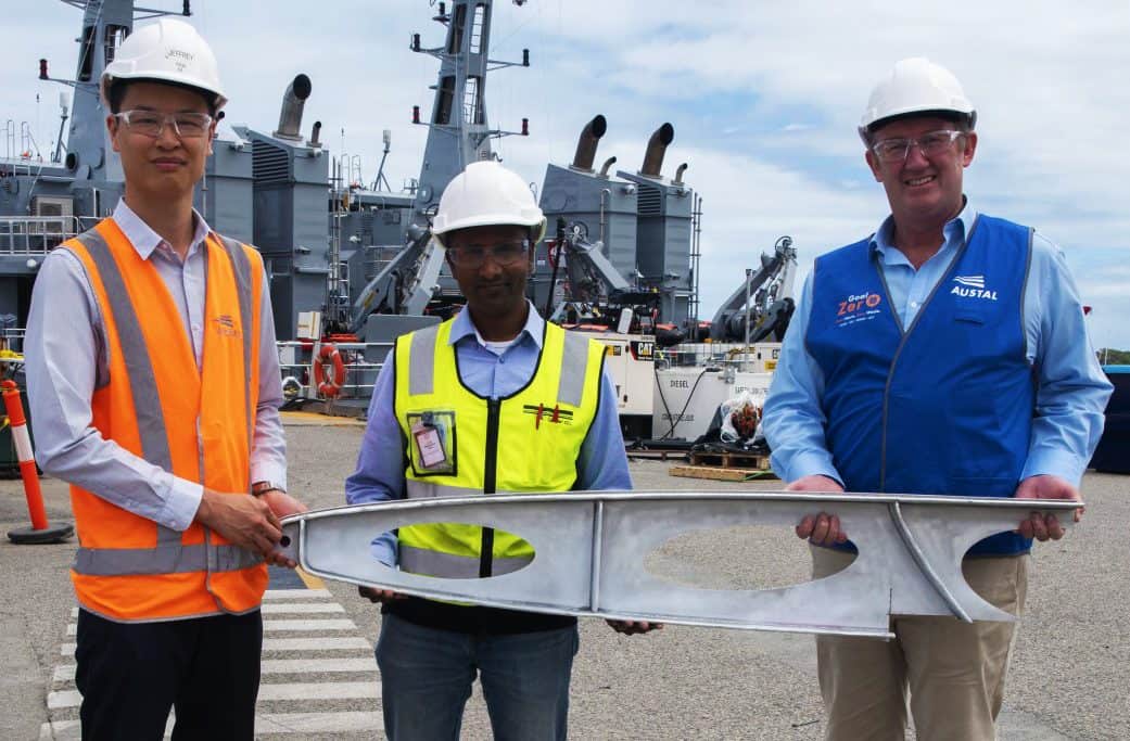 From Left: Austal Technology Project Manager, Jeffrey Poon, DNV Representative Jude Stanislaus, AML3D Chief Executive Officer Andrew Sales with a sample of the davit produced during the additive manufacturing project. (image: Austal Australia)