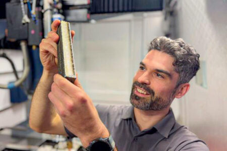 PhD candidate and study lead author Ryan Brooke inspects a sample of the new titanium. - (Michael Quin, RMIT University.)