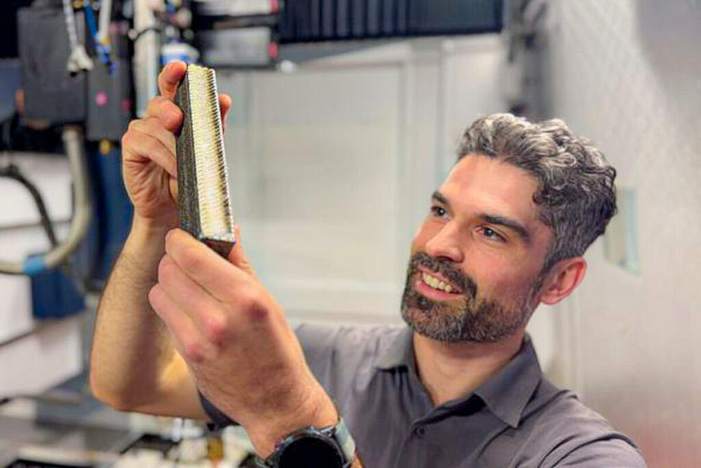 PhD candidate and study lead author Ryan Brooke inspects a sample of the new titanium. - (Michael Quin, RMIT University.)